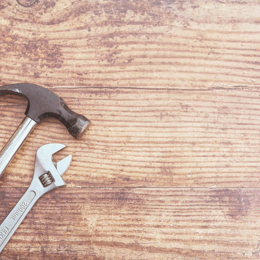 Outils de bricolage posés sur une table en bois pour représenter les services multiservices de COUPDEPOUSSEFRANCAIS